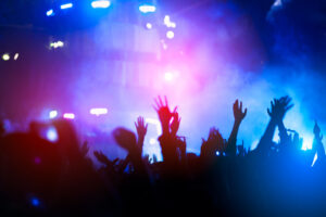 silhouettes of hand in concert.Light from the stage.